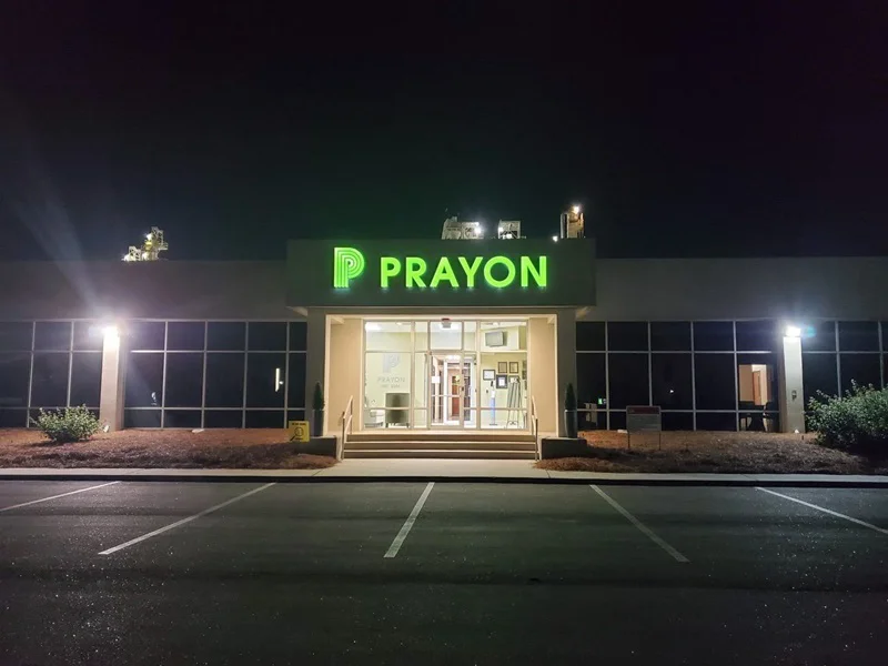 An image of the lit-up Prayon exterior signage.